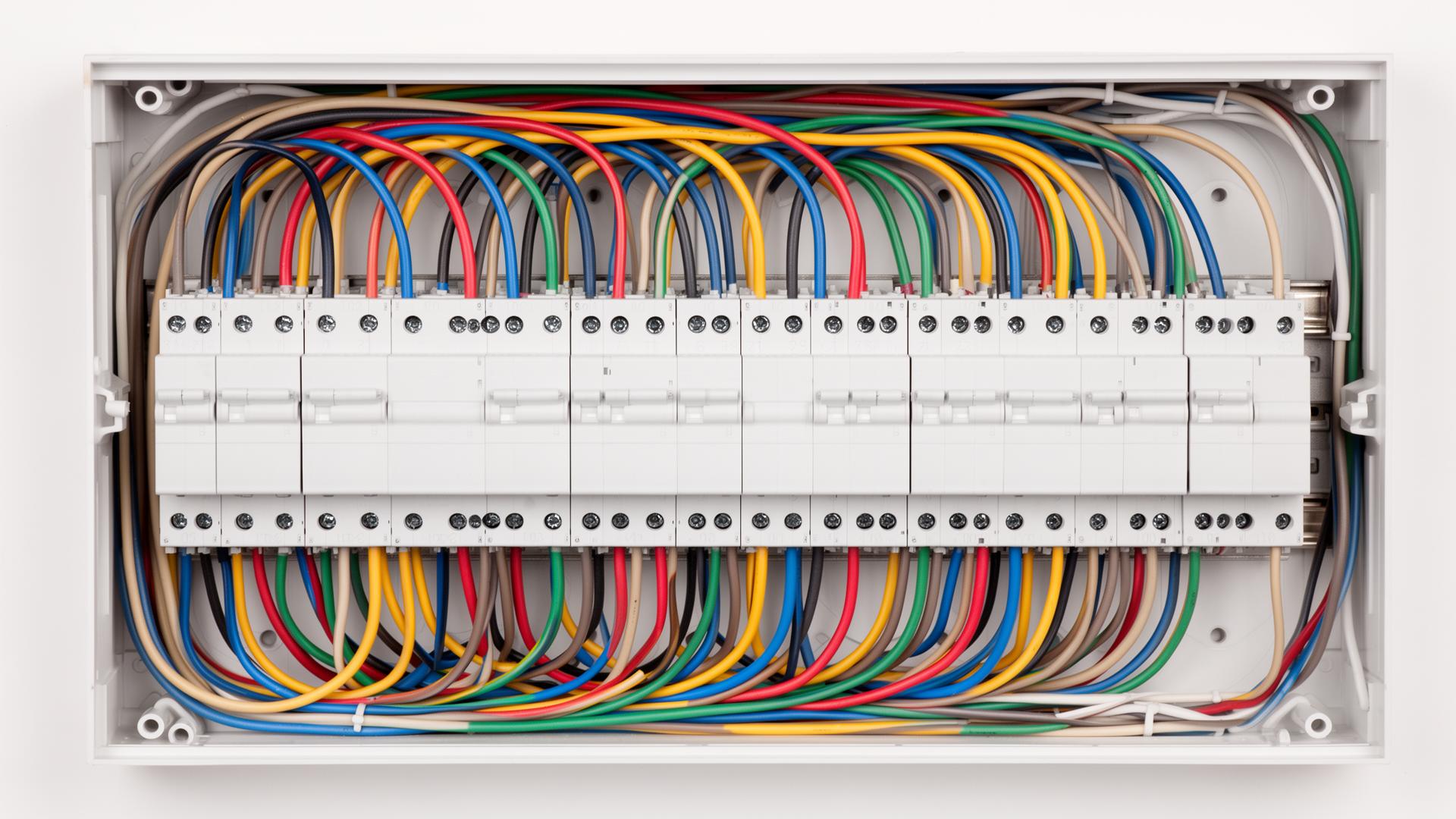 Spectrum electrician wiring a modern consumer unit with neat cable management